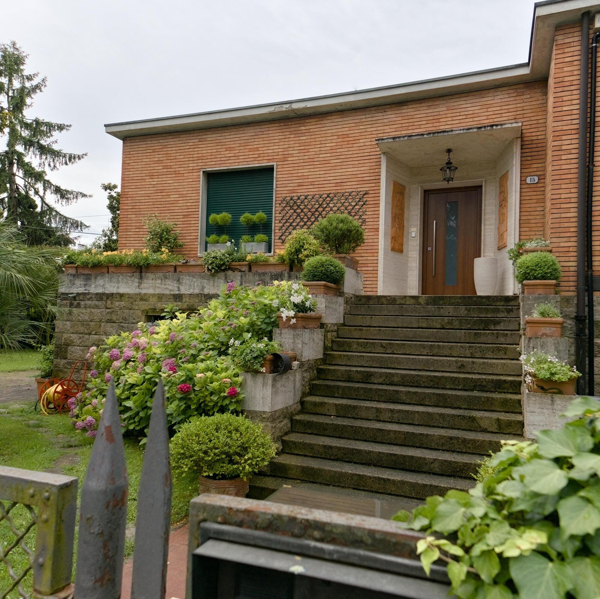 Luigi Strazzabosco, ingresso del civico 31 di via Luigi Negrelli coi bassorilievi in cotto raffiguranti *La famiglia* e *La perseveranza*, anni cinquanta, Padova